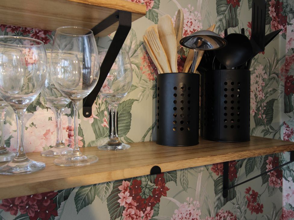 A kitchen with wine glasses and utensils on a shelf at The Trafalgar in Scarborough