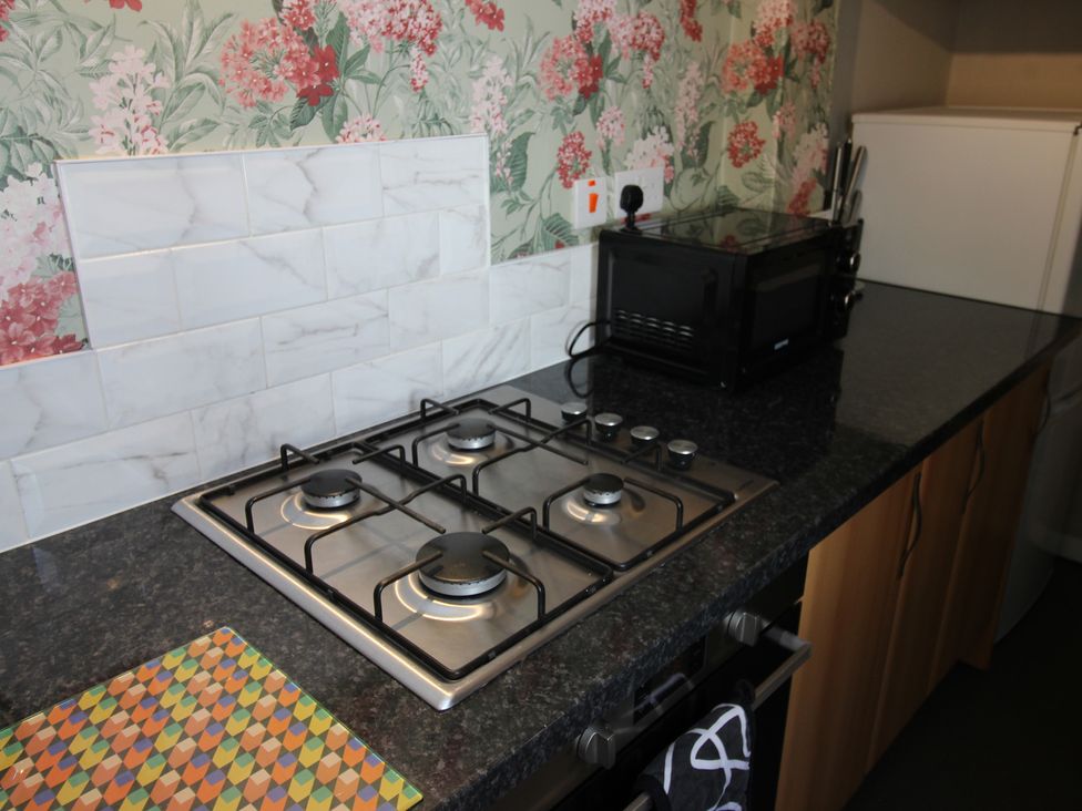 A kitchen with a stove and microwave at The Trafalgar in Scarborough
