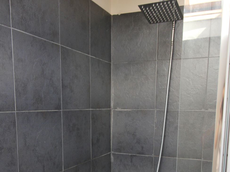 A shower with wall tiles and a shower head at The Trafalgar in Scarborough