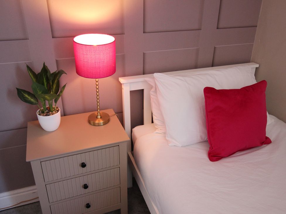 A bedroom with a bed, lamp, and plant at The Trafalgar in Scarborough