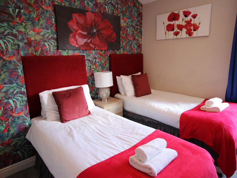 A bedroom with two beds and a nightstand at The Trafalgar in Scarborough