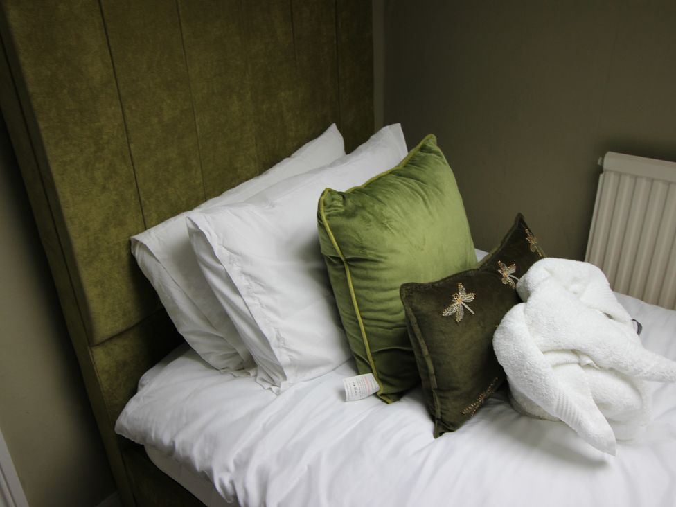 A bed with pillows and a blanket at Brinkburn House in Scarborough