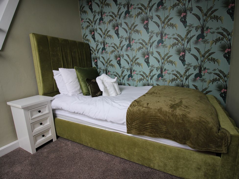 A bedroom with a bed and bedside table at Brinkburn House Scarborough