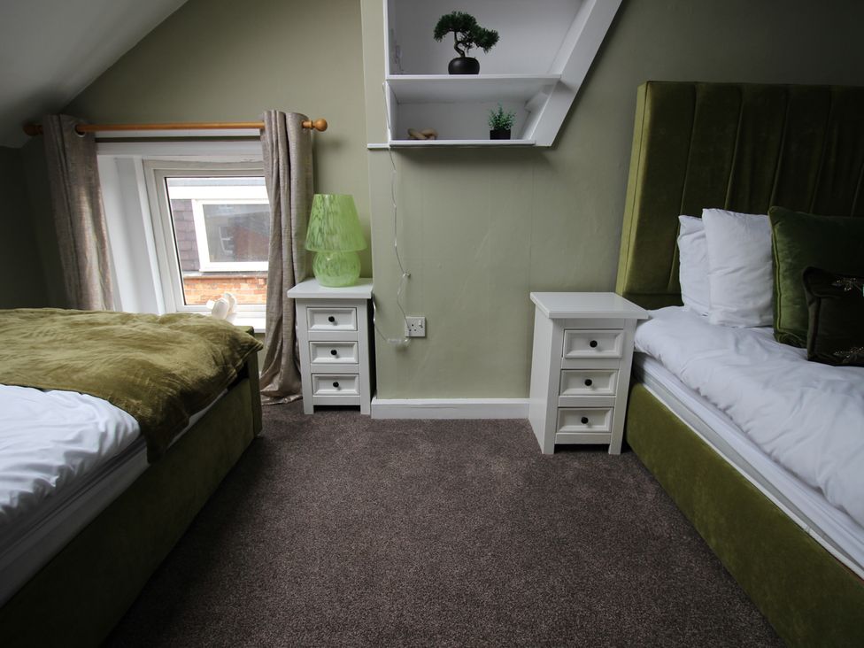 A bedroom with two beds and a nightstand at Brinkburn House in Scarborough