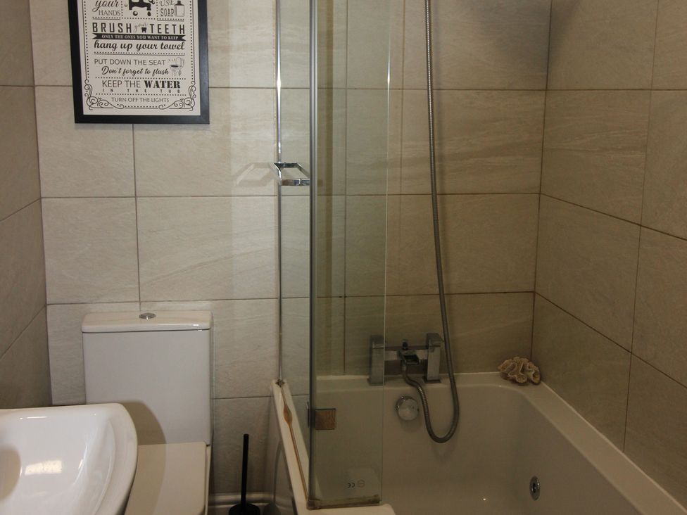A bathroom with a bathtub, toilet, and sink at Brinkburn House in Scarborough