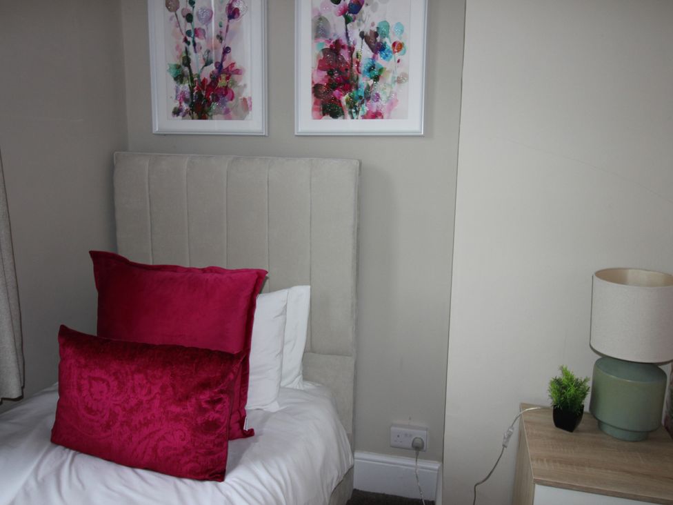 A bedroom with a bed and decorative pillows at Brinkburn House Scarborough