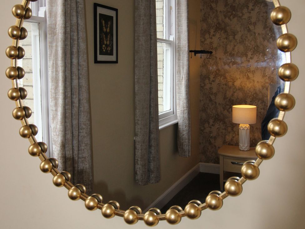 A mirror reflecting a lamp and nightstand at Brinkburn House in Scarborough