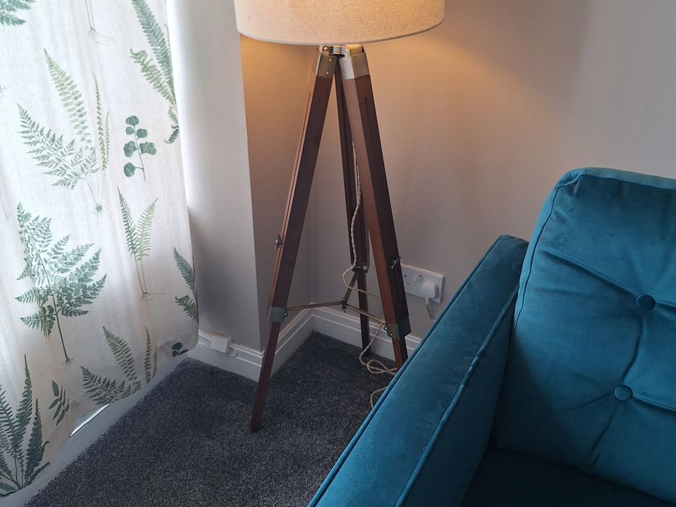 A living room with a lamp and sofa at Old Coach House Apartment in Scarborough