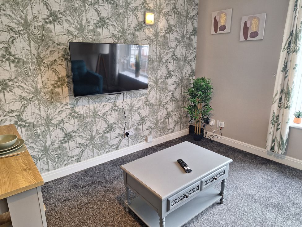 A living room with a television and coffee table at Old Coach House Apartment in Scarborough