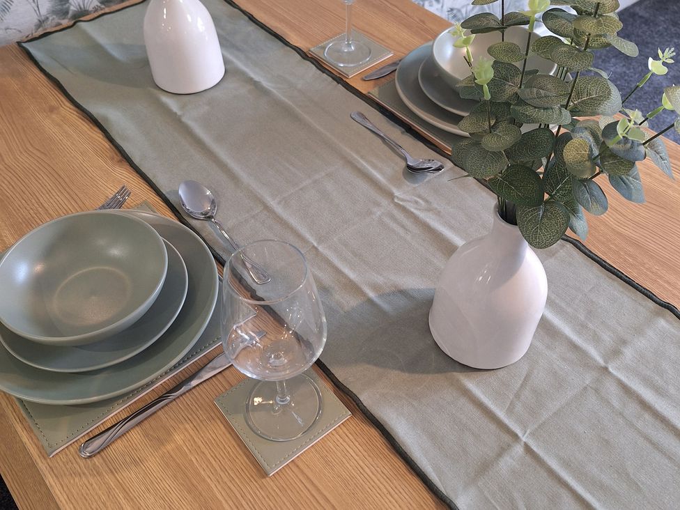 A dining table set with dishes and a vase at Old Coach House Apartment in Scarborough