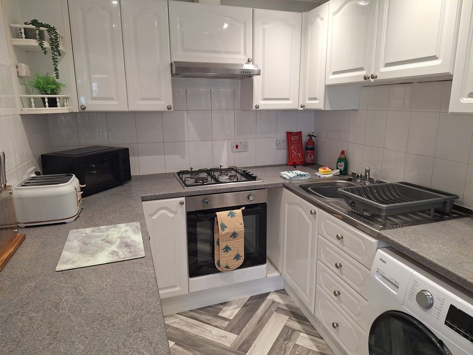 A kitchen with appliances and fixtures at Old Coach House Apartment Scarborough