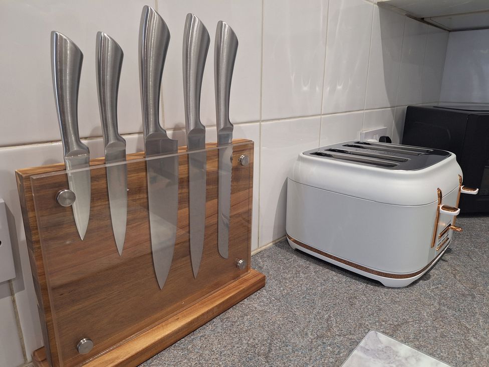 A knife block with kitchen knives and a toaster at Old Coach House Apartment in Scarborough