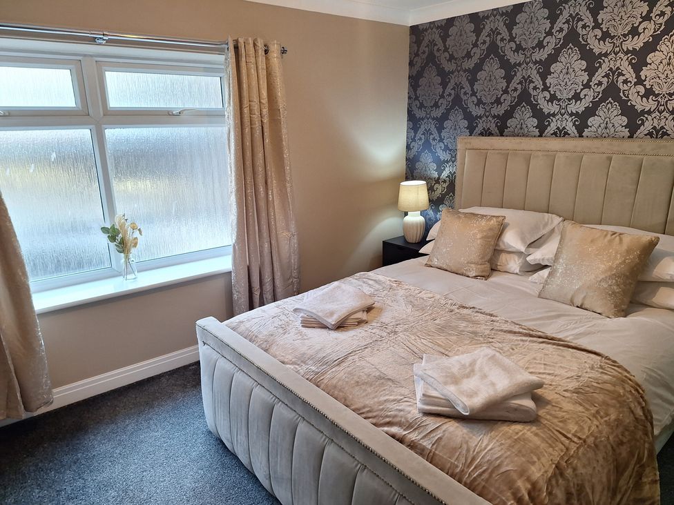 A bedroom with a bed and bedside table at Old Coach House Apartment in Scarborough