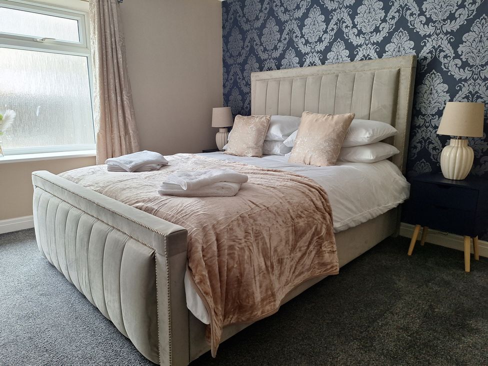 A bedroom with a bed and lamp at Old Coach House Apartment in Scarborough