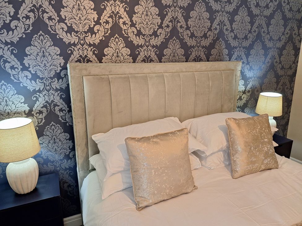 A bedroom with a bed and pillows at Old Coach House Apartment in Scarborough