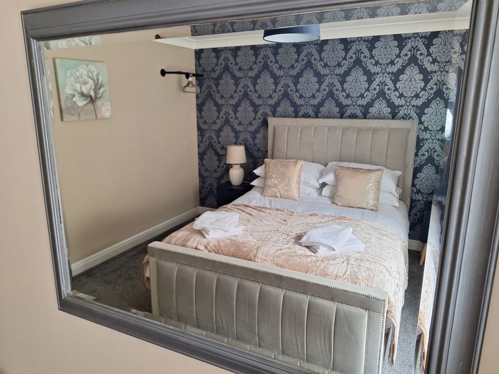 A bedroom with a bed and lamp at Old Coach House Apartment Scarborough