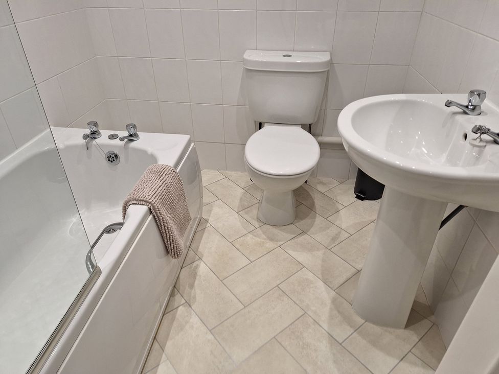 A bathroom with a bathtub, toilet, and washbasin at Old Coach House Apartment in Scarborough