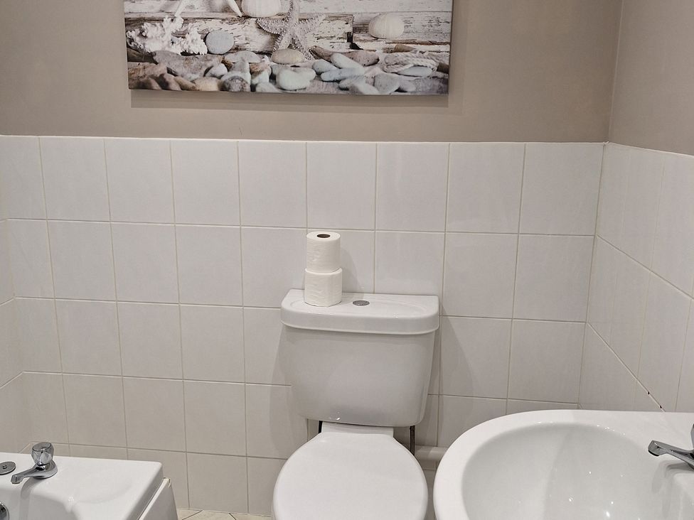 A bathroom with a toilet and sink at Old Coach House Apartment Scarborough