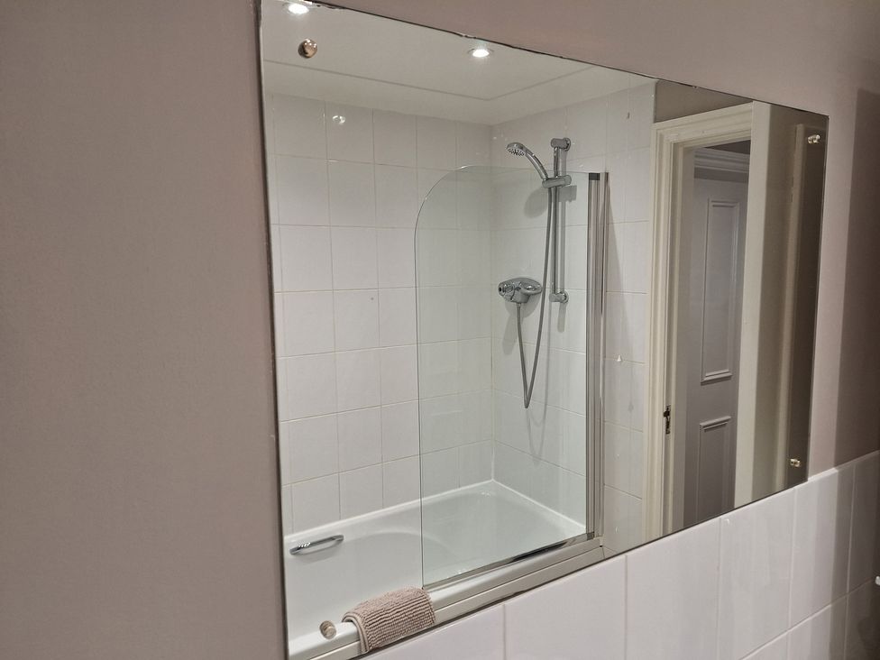 A bathroom with a bath tub and shower at Old Coach House Apartment in Scarborough