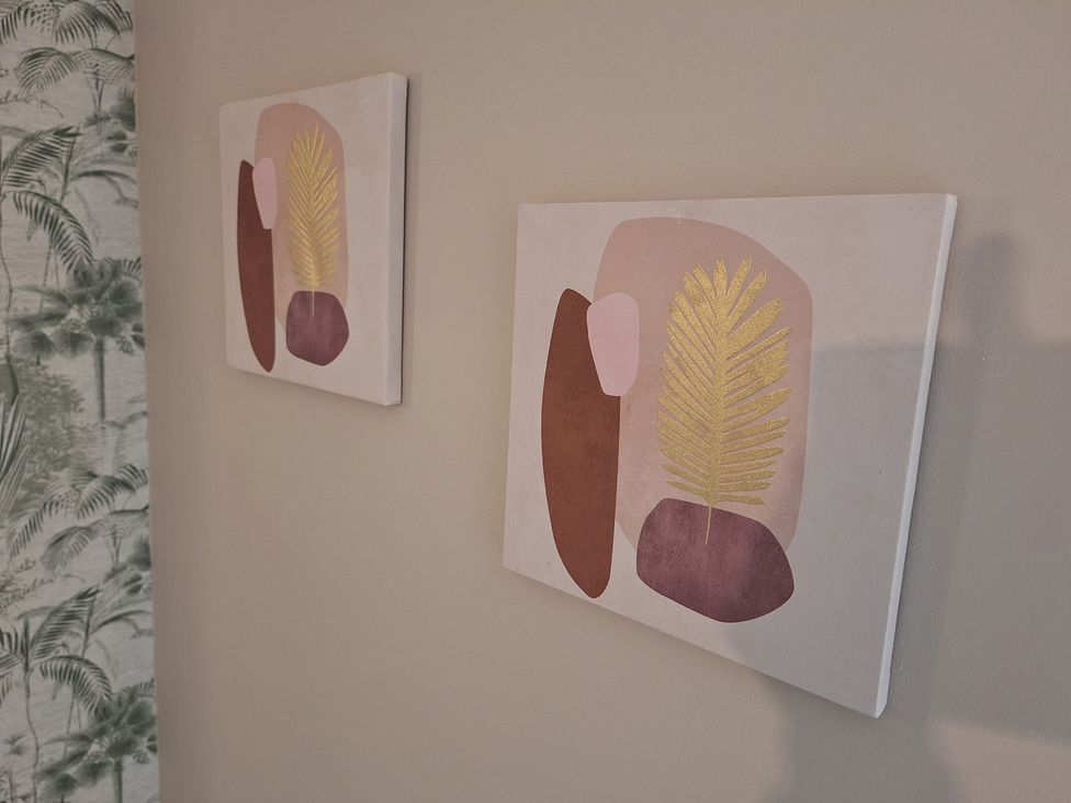 Two decorative paintings on a wall at Old Coach House Apartment in Scarborough
