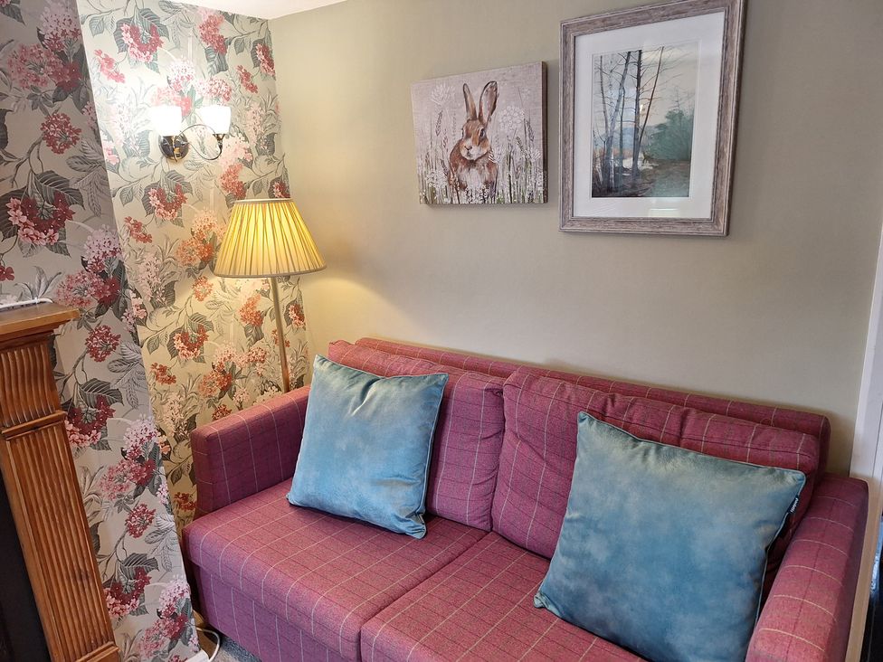 A living room with a sofa and cushions at Fryers Cottage in Seamer, North Yorkshire