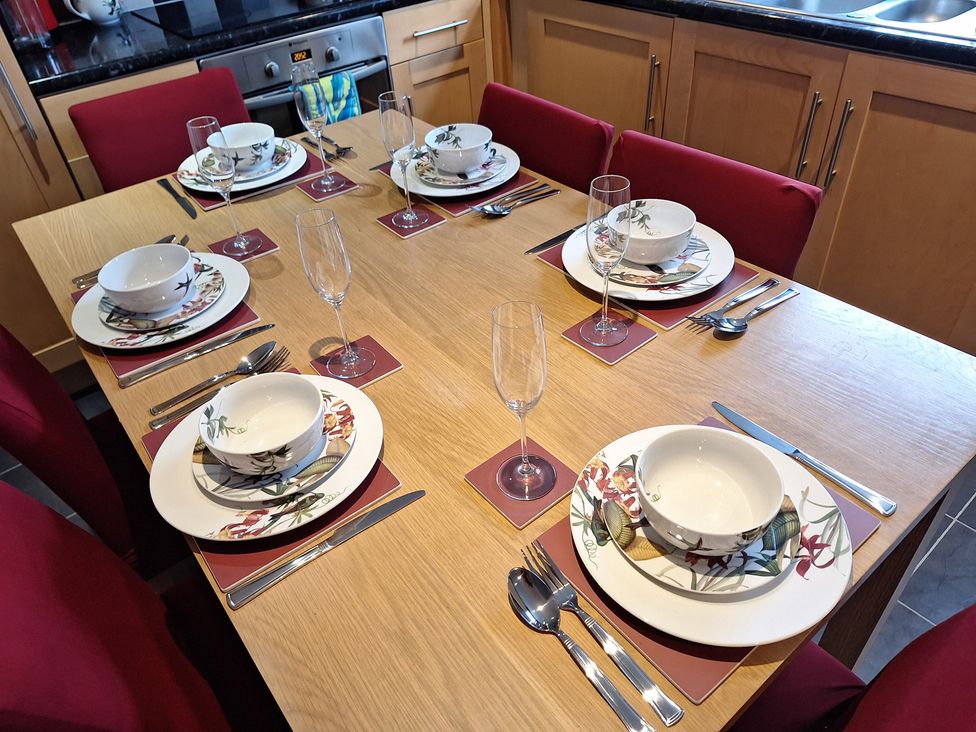 A dining table set with plates and glasses at Fryers Cottage Seamer, North Yorkshire