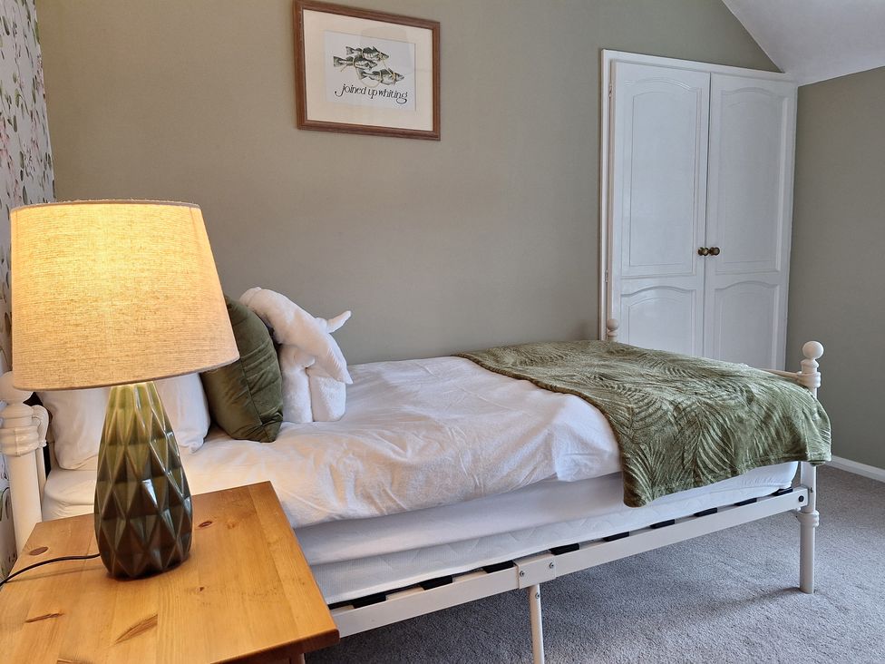 A bedroom with a bed and a lamp at Fryers Cottage, Seamer, North Yorkshire