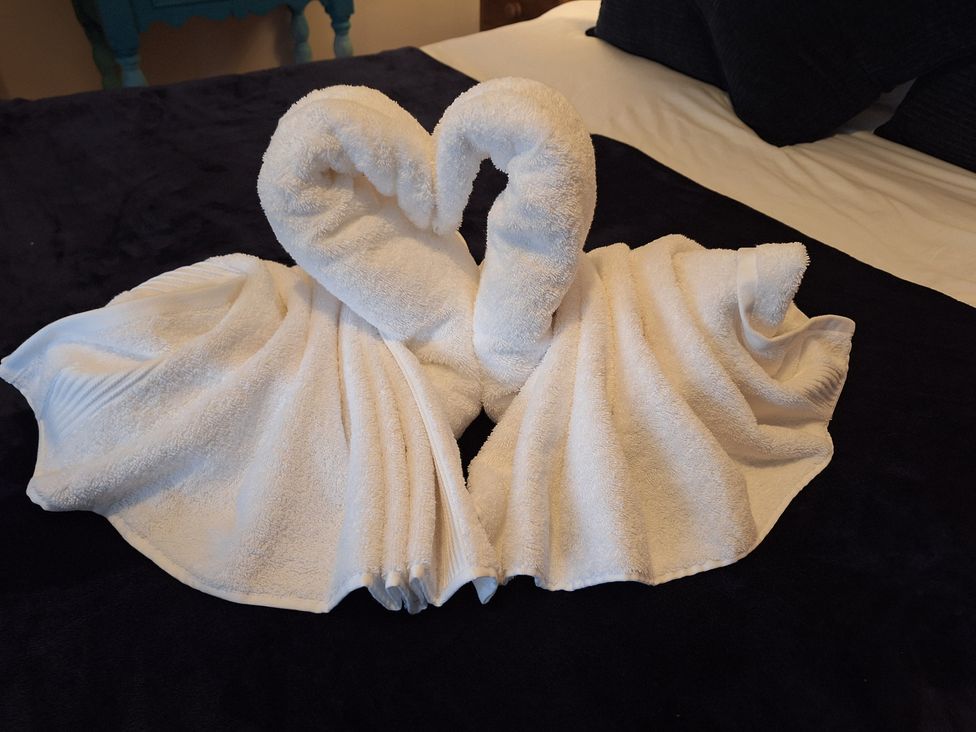 Two towel swans on a bed at Fryers Cottage, Seamer, North Yorkshire