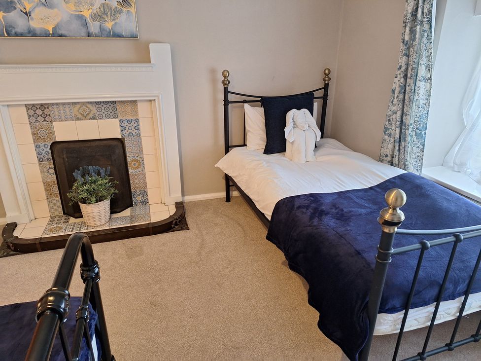 A bedroom with a bed and a fireplace at Fryers Cottage in Seamer, North Yorkshire