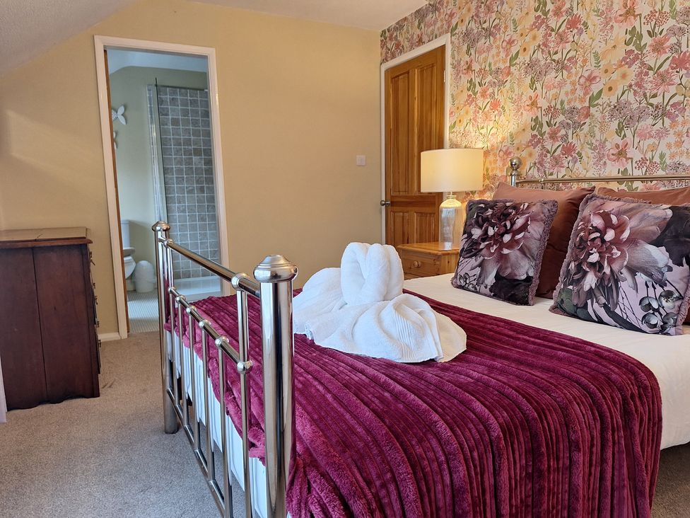 A bedroom with a bed and towels arranged at Fryers Cottage in Seamer, North Yorkshire