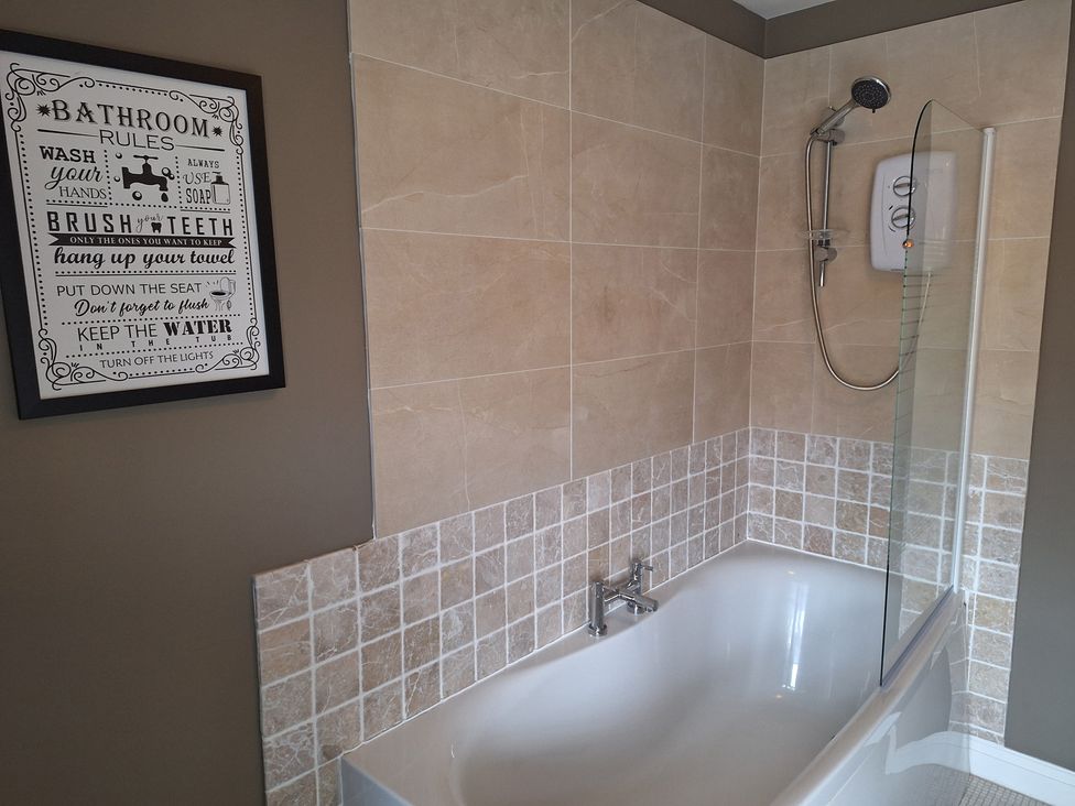 A bathroom with a bathtub and shower at Fryers Cottage Seamer, North Yorkshire