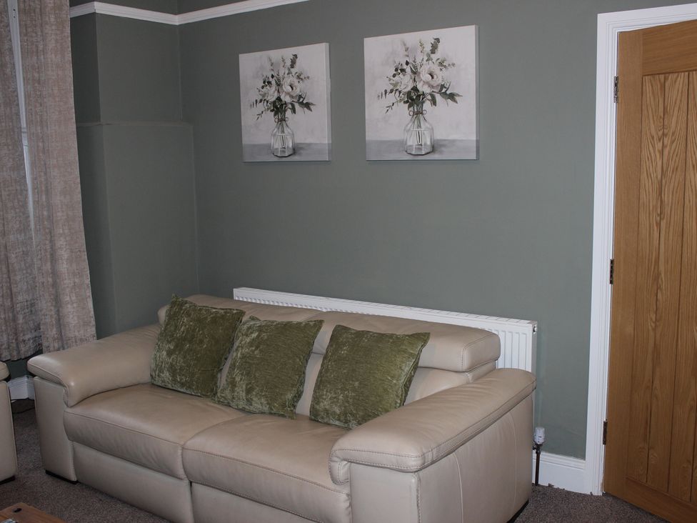 A living room with a sofa and wall art at Blackburn Heights Apartment 1 in Bridlington