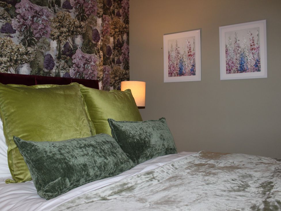 A bedroom with pillows on a bed and wall art at Blackburn Heights Apartment 1 Bridlington