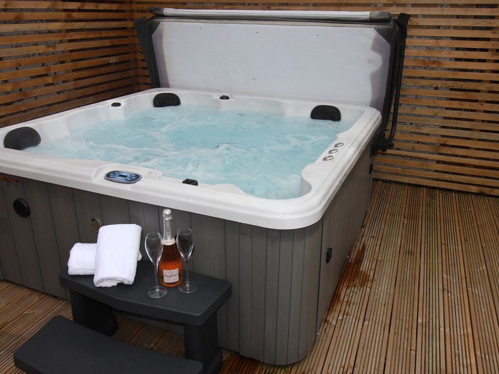A hot tub with towels and champagne at Blackburn Heights Apartment 1 in Bridlington