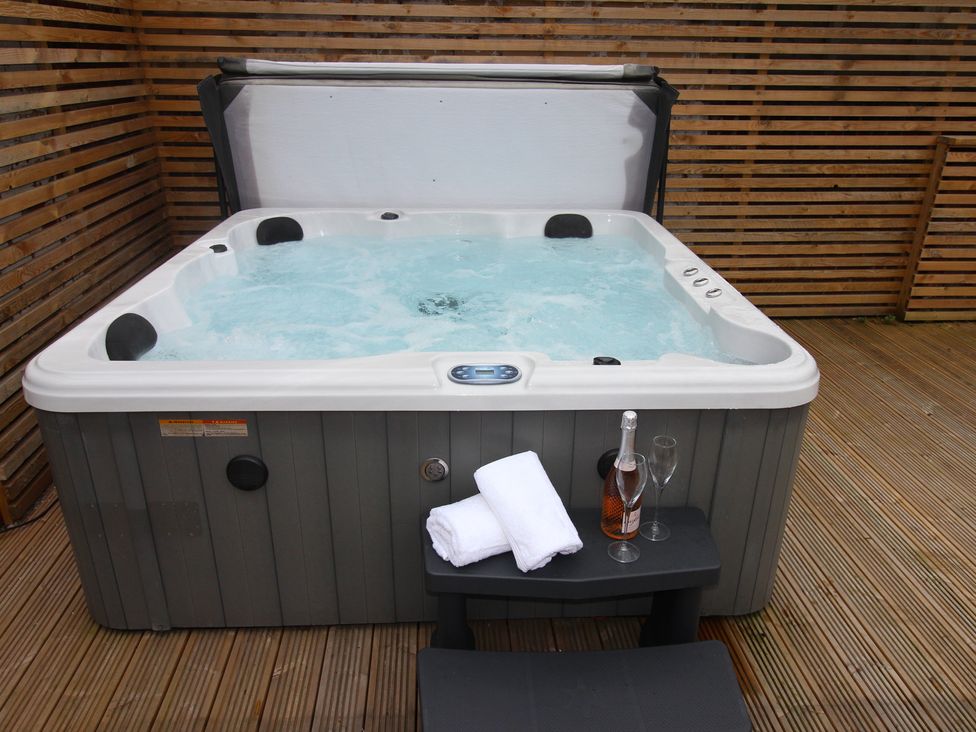 A hot tub with towels and wine glasses in an outdoor area at Blackburn Heights Apartment 1, Bridlington