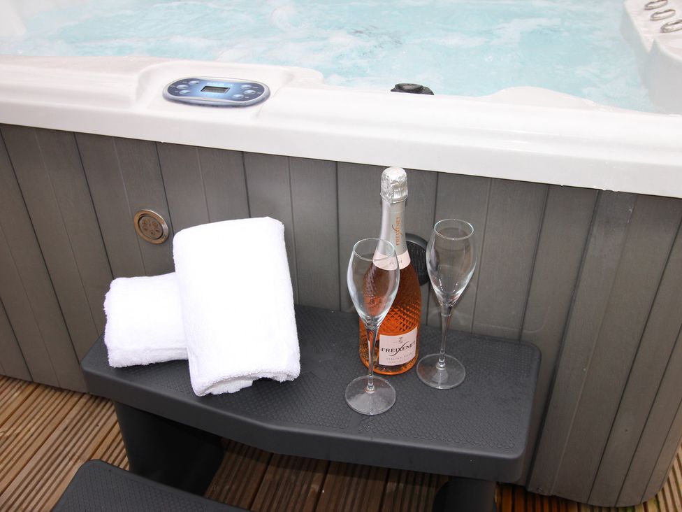 A hot tub with towels and champagne in an outdoor area at Blackburn Heights Apartment 1 in Bridlington