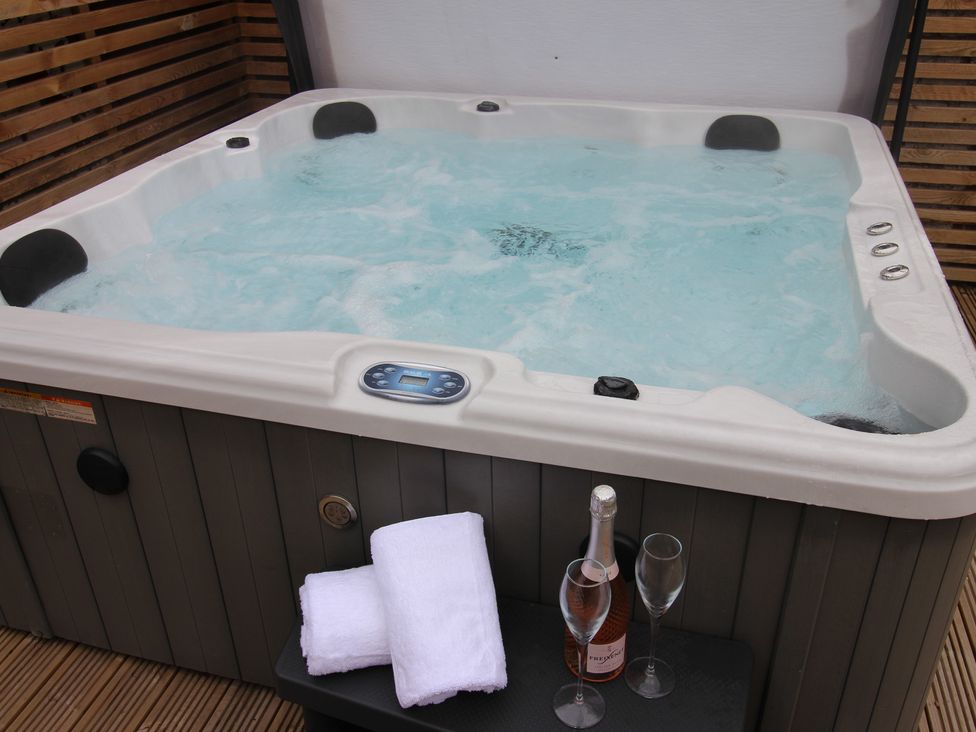 A hot tub with champagne glasses and towels at Blackburn Heights Apartment 1 in Bridlington