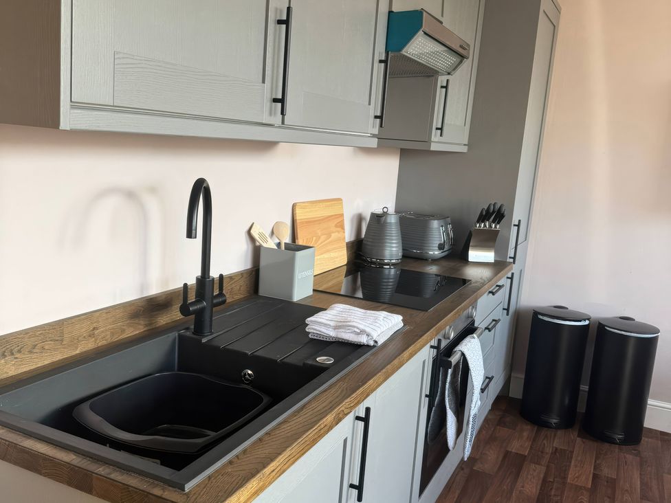 A kitchen with a sink and stove at Blackburn Heights Apartment 3 in Bridlington
