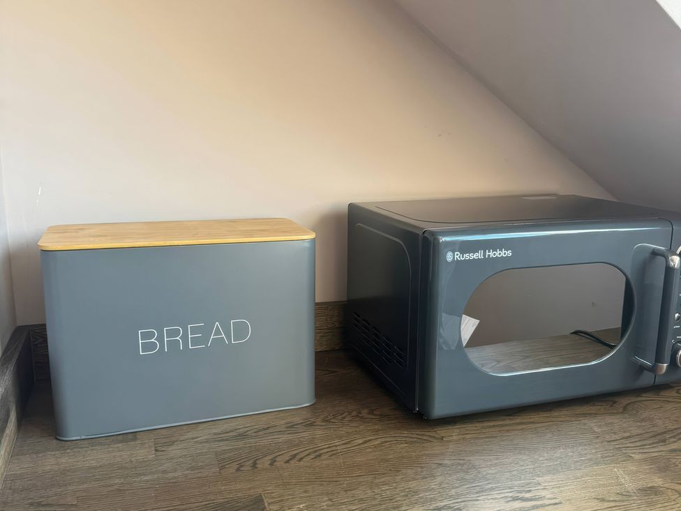 A bread bin and a microwave at Blackburn Heights Apartment 3 in Bridlington