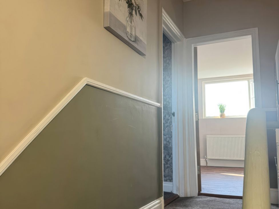 A staircase and hallway with a door and window at Blackburn Heights Apartment 3 in Bridlington
