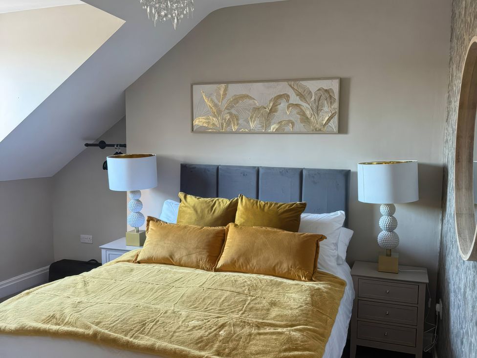 A bedroom with a bed and lamps at Blackburn Heights Apartment 3 in Bridlington
