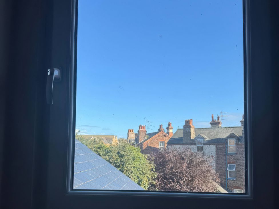 A view from a window showing rooftops and blue sky at Blackburn Heights Apartment 3 in Bridlington