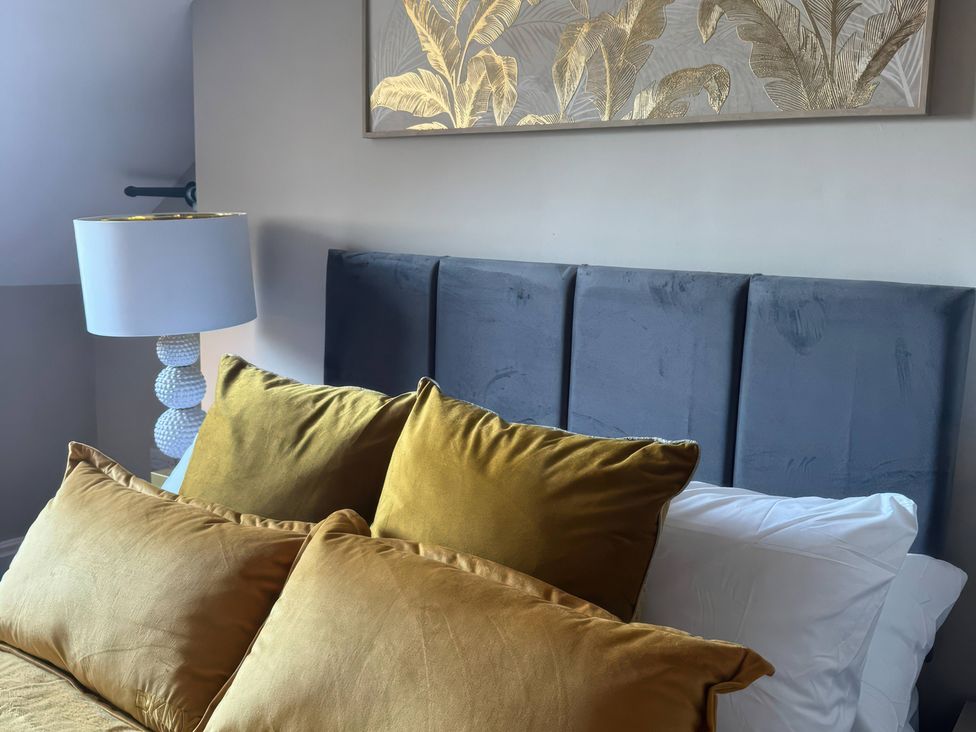 A bedroom with a bed and cushions at Blackburn Heights Apartment 3 in Bridlington