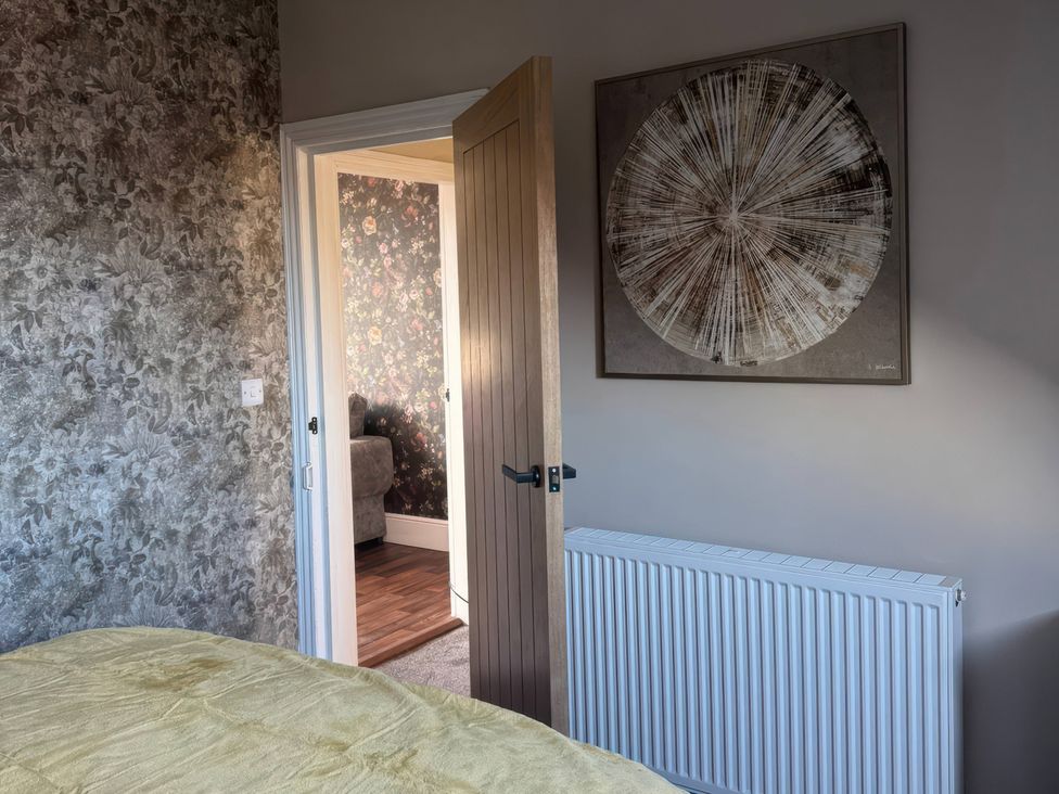 A bedroom with a bed and open door at Blackburn Heights Apartment 3 in Bridlington