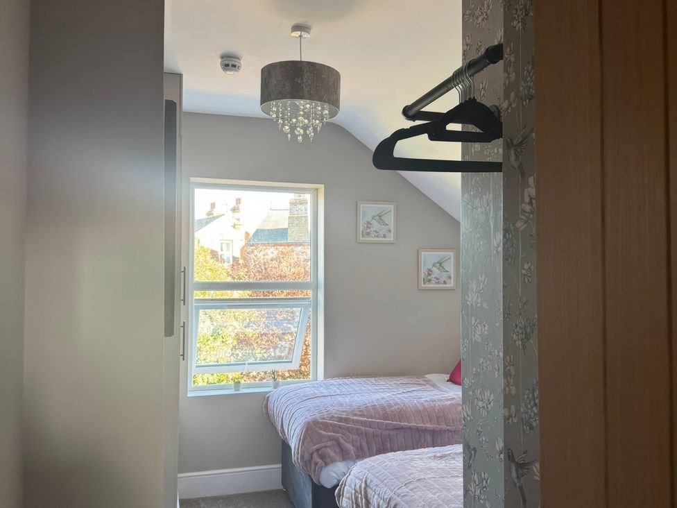 A bedroom with two beds and a window at Blackburn Heights Apartment 3 in Bridlington
