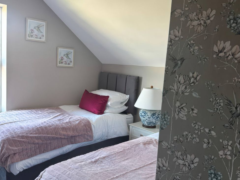 A bedroom with two beds and wall art at Blackburn Heights Apartment 3 in Bridlington
