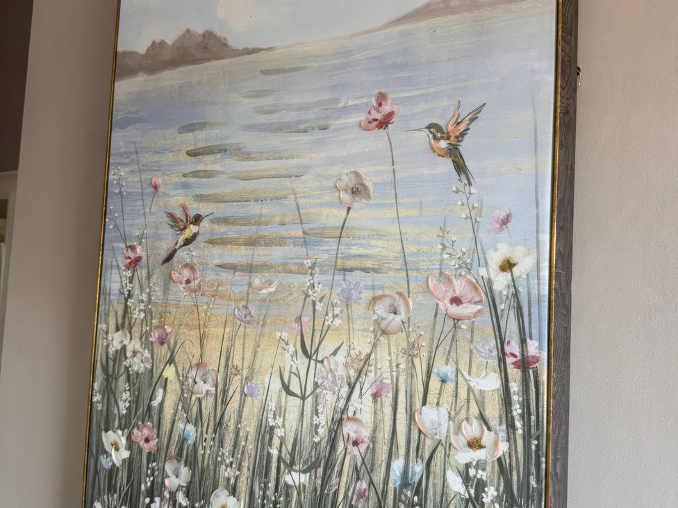 A painting depicting flowers and birds with a water landscape at Blackburn Heights Apartment 3, Bridlington