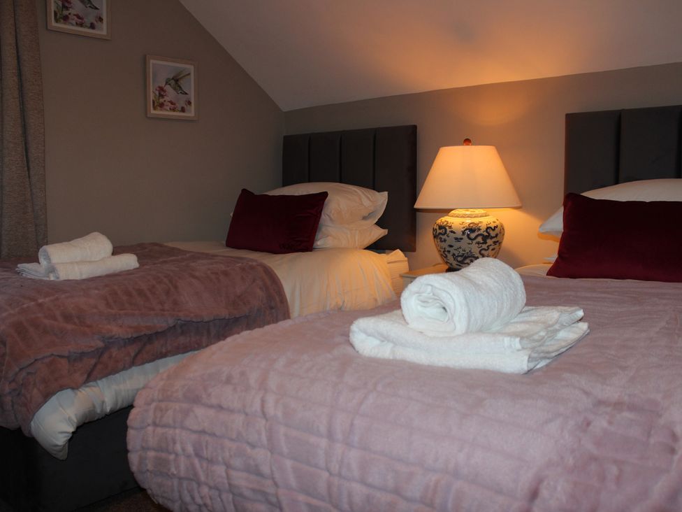 A bedroom with two beds, pillows, and a lamp at Blackburn Heights Apartment 3, Bridlington