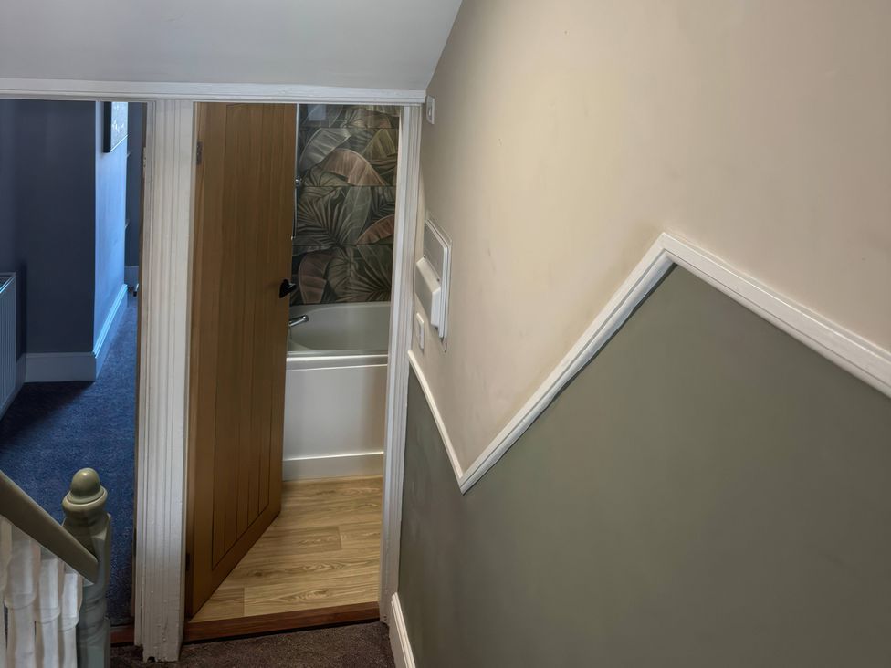 A bathroom with a tub visible from a staircase at Blackburn Heights Apartment 3 Bridlington