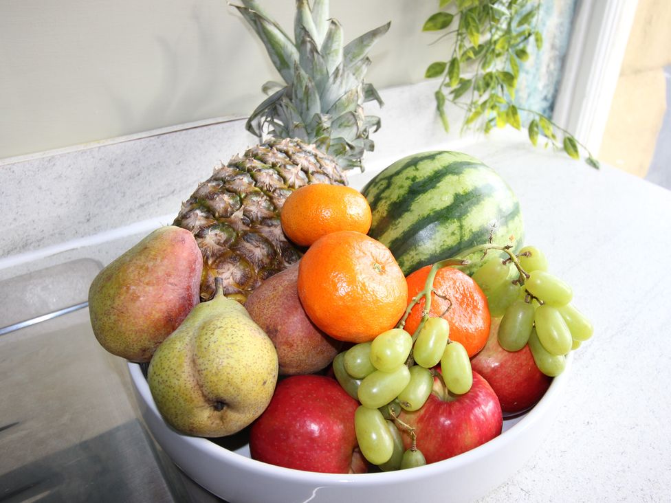 A bowl of assorted fruits including pineapple and watermelon at Cornerhouse Apartment 1 Llandudno